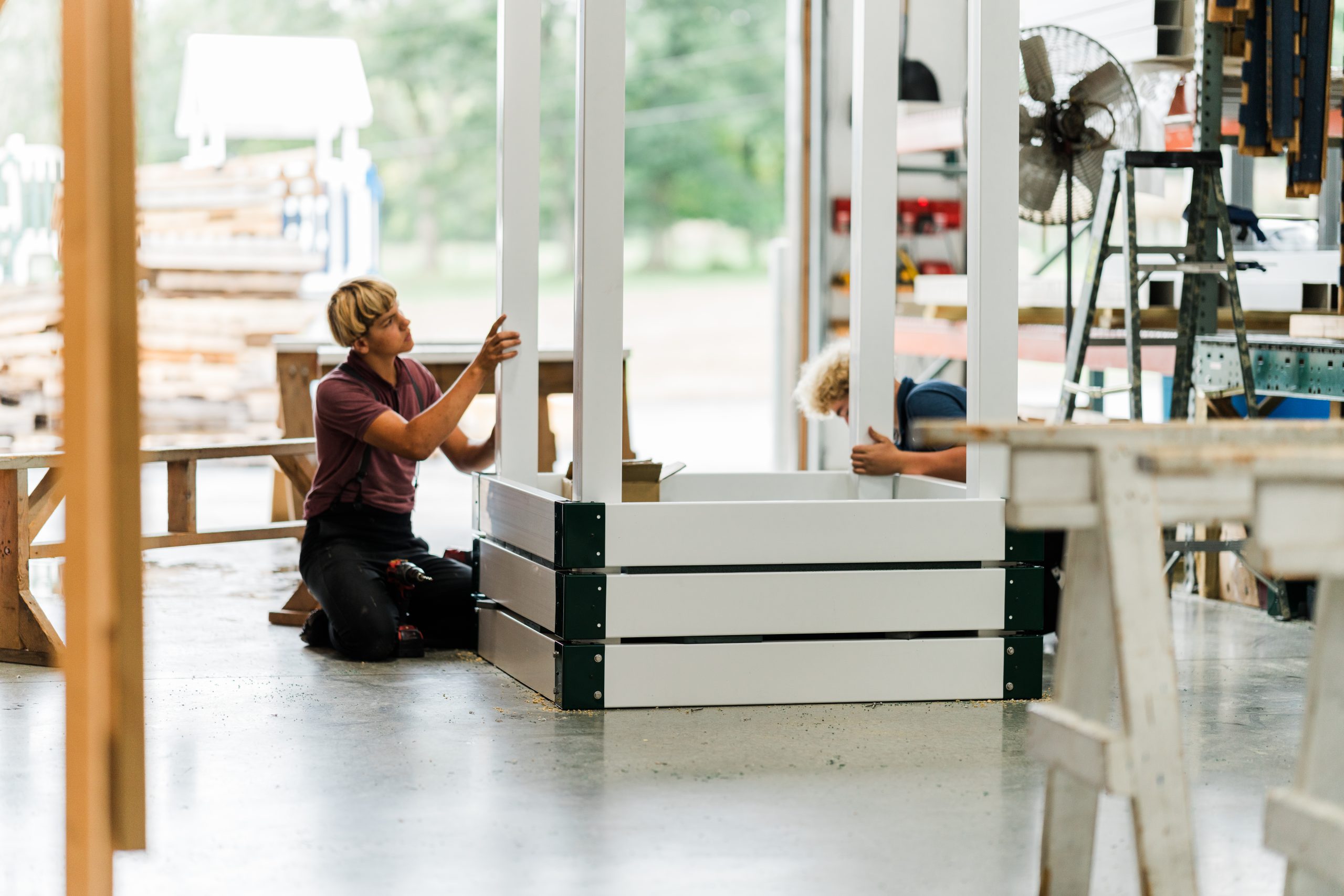 amish workers building a vinyl swing set at star quality swingsets