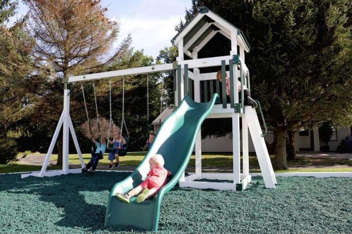 children playing on white and green star cluster backyard swing set