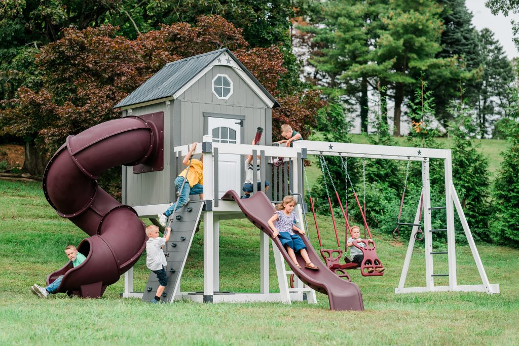 Playhouse with slate gray walls, black roof and red slides