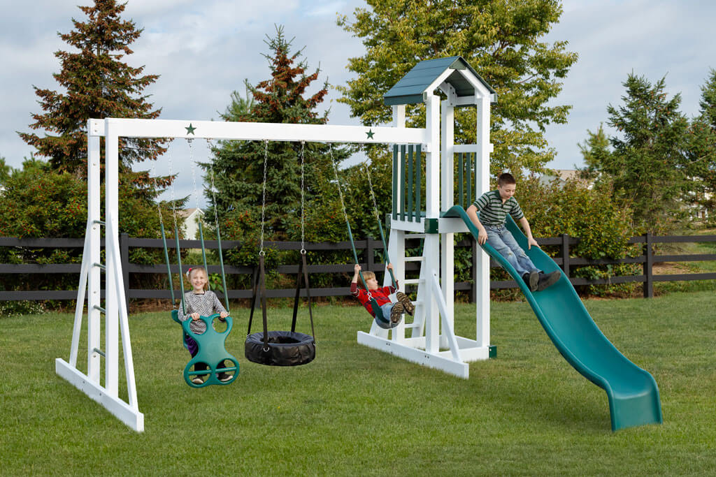 children on swings and slide of a green three swing set