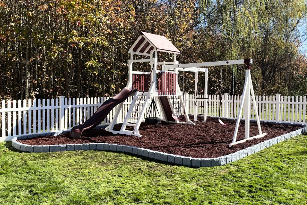Red rubber mulch with red and white swingset