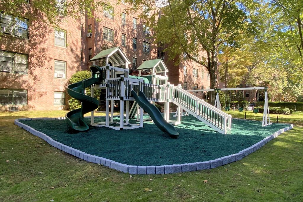 Green rubber mulch with green and white playset