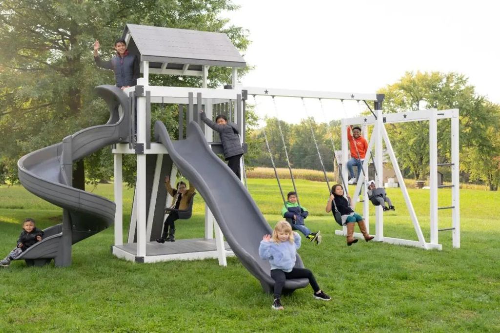 Modern gray and white swingset with rock wall 
