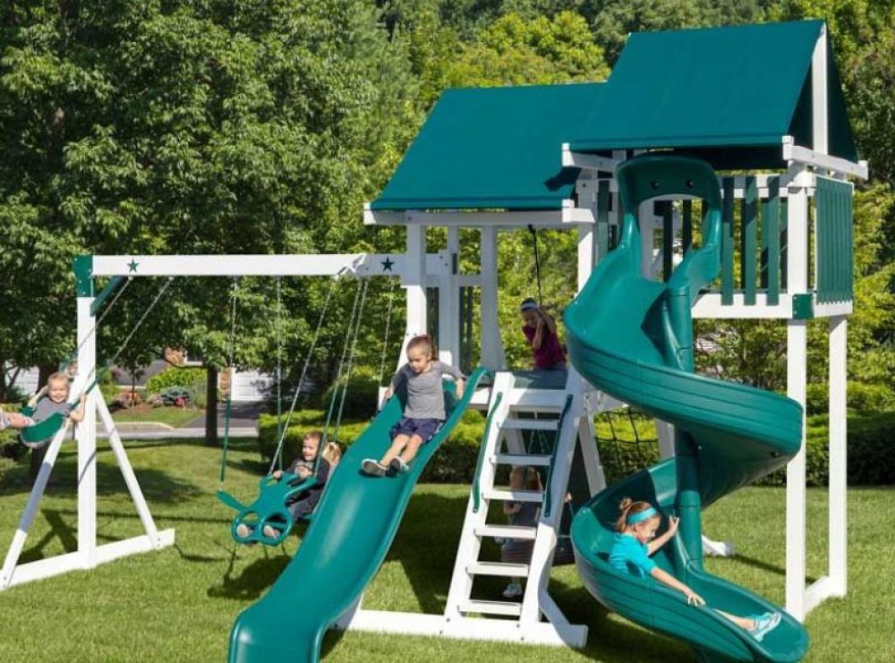 multi level playset with two towers that have green canvas roofs over them in a backyard
