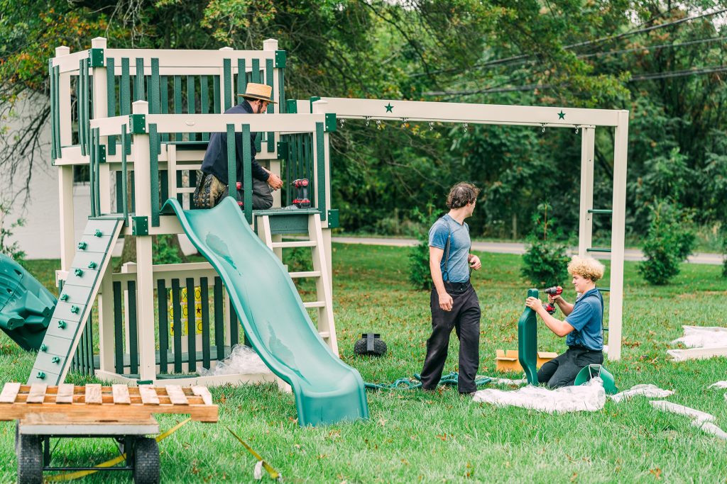 Amish crew installing a swingset