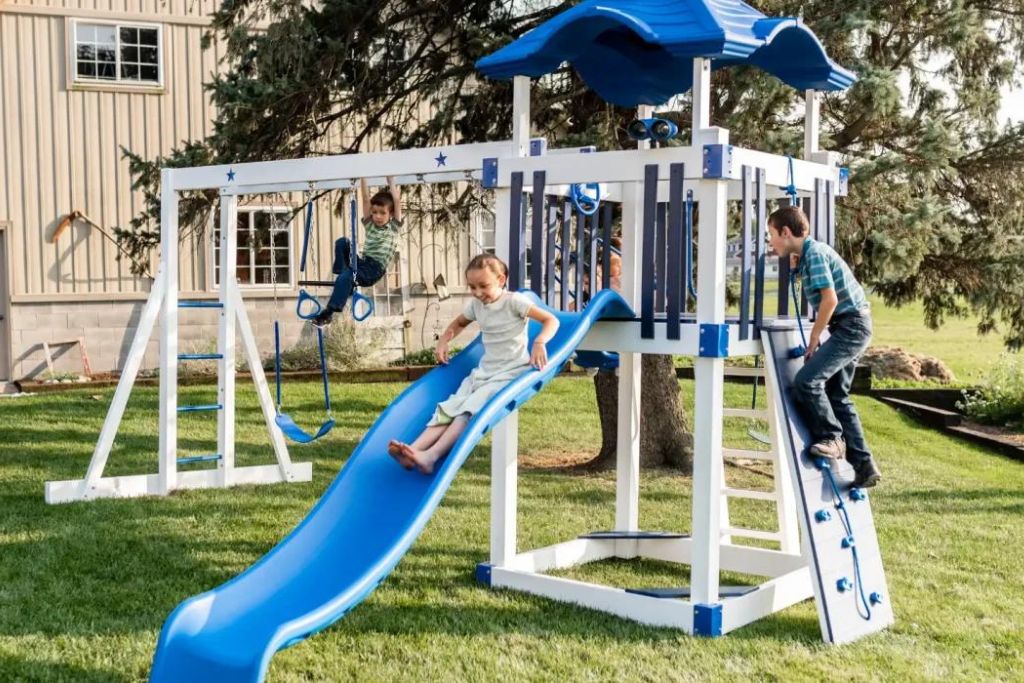 Blue and white swing set with climbing wall 